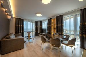 a living room with a couch and a table and chairs at Santa Maria Luxury Suits in Ravda