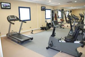 a gym with treadmills and elliptical machines at Hotel Madeira Centro in Benidorm