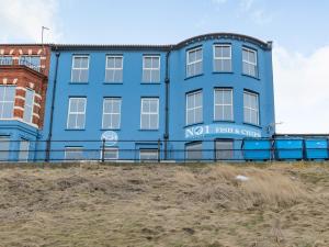 a blue building on the side of a beach at The Perch-Uk37325 in Cromer