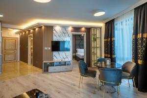 a living room with a tv and a table and chairs at Santa Maria Luxury Suits in Ravda