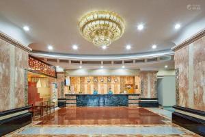 a large room with a bar and a chandelier at Kaiserdom Hotel Guangzhou Huangshidong Road Branch in Guangzhou