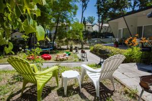 three chairs and a table in a garden at Albatross Family Nest Breeze Bungalow in Varna City