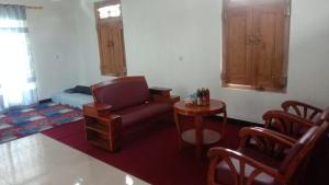 a living room with a chair and a table at Naufal homestay & kost in Ngemplak +1 photo