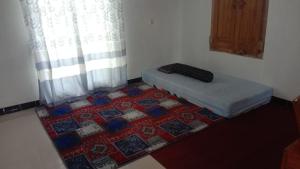 a room with a bed and a rug on the floor at Naufal homestay & kost in Ngemplak