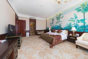 a large hotel room with a bed and a television at Evergrande Hotel Guangzhou Zengcheng in Zhongxin