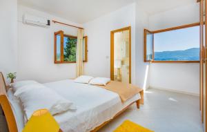 a white bedroom with a bed and a window at Apartment Lujak in Koločep