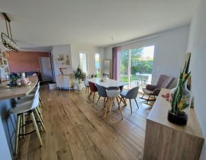 LéguevinにあるVilla entière avec piscine- 8pのテーブルと椅子のあるキッチンとリビングルーム