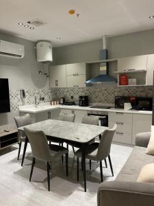 a kitchen with a table and chairs in a room at شقق في الحمرا هاي رايز in Al Khobar
