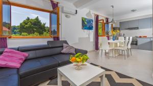 a living room with a blue couch and a table at Apartment Lujak in Koločep