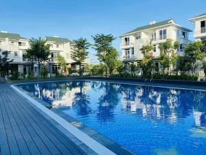 Una gran piscina frente a unos edificios. en Ana La Vie Hue, en Thôn Lại Thê