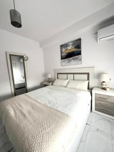 ein weißes Schlafzimmer mit einem großen Bett und einem Gemälde an der Wand in der Unterkunft Aguadulce bay apartments 1 in Aguadulce