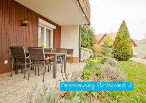 un patio con sillas y una mesa en el lateral de una casa en Ferienwohnung Storchennest 2, en Waldshut-Tiengen