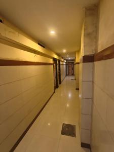 a corridor of a building with white walls and a hallway at Hotel Vishal in Surat +2 photos