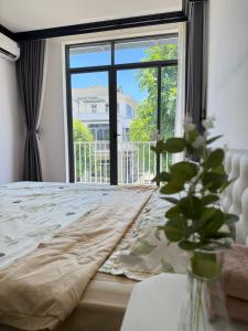 Un dormitorio con una cama con una ventana grande. en Ana La Vie Hue, en Thôn Lại Thê