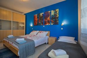 een slaapkamer met 2 bedden en een blauwe muur bij Apartment Zdravka in Hvar