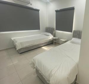 a bedroom with two beds and a large screen at See U Impiana Bentong Homestay in Bentong