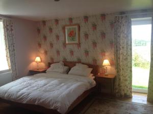 a bedroom with a bed with two lamps on two tables at Barcloy Milk House in Kirkcudbright