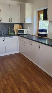 a kitchen with white cabinets and a microwave at Ferienwohnung Haus Julia in Mariapfarr