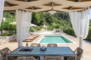 a patio with a table and a swimming pool at Mater Terra-Private Villa in Sami