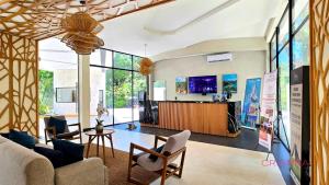 a living room with a couch and chairs and a counter at Tulum Escape - Private Hot Tub, Steps to Free Beach in Tulum