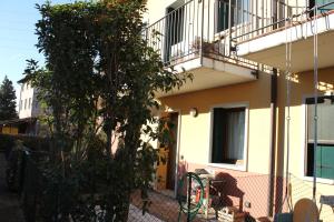 a tree in front of a house with a balcony at Jasmine Country House in Vicenza