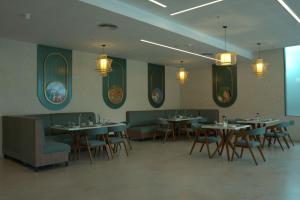 a dining room with tables and chairs and lights at Arcor Hotels Mysuru in Mysore