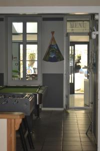 a room with a pool table and a sign on the wall at Chambre d'hôte avec piscine partagé à disposition in Chef-Boutonne