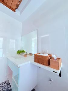 a white bathroom with a sink and a mirror at 金樽浪花 in Chin-tsun