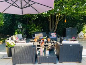 eine Terrasse mit Tisch, Stühlen und Sonnenschirm in der Unterkunft Le 8 in Mutzig