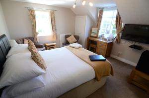 a bedroom with a bed and a flat screen tv at Ellerby Country Inn in Ellerby