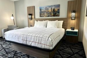 ロズウェルにあるLa Quinta by Wyndham Atlanta Roswellのベッド、デスク、ベッドサイドシックスが備わるホテルルームです。