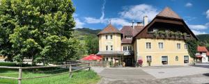 a large yellow building with a gambrel roof at Landhotel Restaurant Hubinger in Thörl
