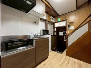a small kitchen with a sink and a microwave at Akabane Nishi kodate AN1 in Tokyo