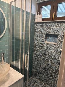 a bathroom with a shower with green tiled walls at Mermaid Cove in Sukošan +10 photos