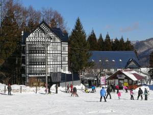 a group of people in the snow in front of a building at Hakuba Sun Valley Hotel Annex - Vacation STAY 90337v in Iida