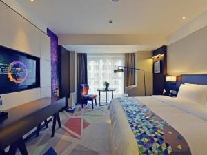 a hotel room with a large bed and a desk at Zmax Hotel·Xining Wanda Plaza in Xining