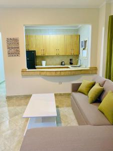 ein Wohnzimmer mit Couch und Küche in der Unterkunft Magawish Hurghada Apartement 1 in Hurghada