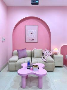 Sala de estar de color rosa con sofá y mesa en 602DinhThon, en Hanói
