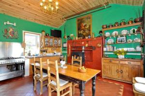 a kitchen with a wooden table and green walls at Errisbeg House B&B in Roundstone +32 photos