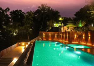 a swimming pool at night with lights on it at Delano Residency in Kaliyal