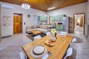a kitchen and living room with a wooden table and chairs at Kapa Luxury House in Krokeaí