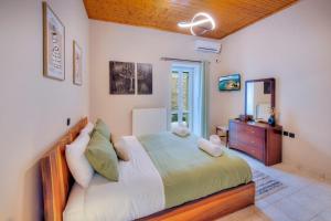 Un dormitorio con una cama grande y una cómoda. en Kapa Luxury House, en Krokeaí
