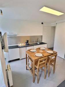 a kitchen with a wooden table and chairs in a room at Wonderhost, aux abords de Beaumont in Pau