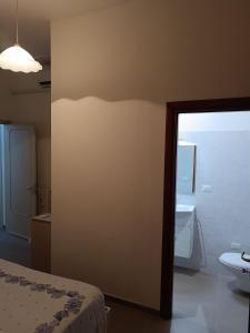 a room with a bed and a bathroom with a mirror at Casa Vacanze Salento in Matino