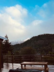 Un banco de madera situado encima de una plataforma de madera. en Cabaña De Montaña Ámber II, en San Carlos de Bariloche