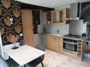a kitchen with a table and a stove top oven at Love Room, L'aubertine in Putanges