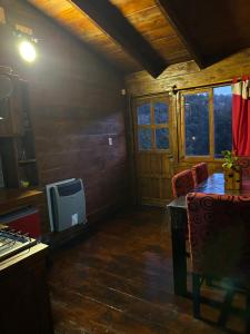 Una sala de estar con una mesa y un televisor. en Cabaña De Montaña Ámber II, en San Carlos de Bariloche