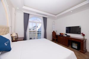 富国Emirates Hotel Phu Quoc的一间带大床和电视的卧室