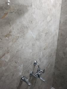 a shower with two faucets in a bathroom at Home stay in varanasi by gaurav in Ahraurā Road