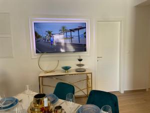 a dining room with a table with chairs and a television at Luxury Villa Olga in Biograd na Moru